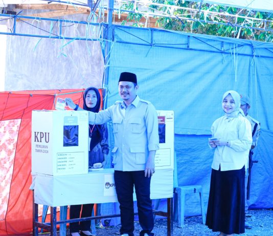 Petahana Bupati Koltim Abd Azis Didampingi Istri Hartini Azis Salurkan Hak Suaranya di TPS 2 Desa Matabondu